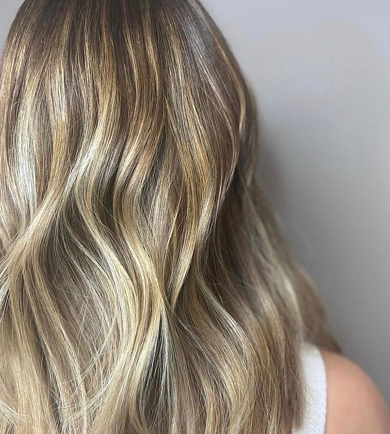The back of a young woman's head showing her balayage colour